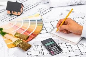 Verbrauchsberechnung - Geschäftsmann, der mit einem Taschenrechner arbeitet und auf Notizbuch schreibt. Baupläne mit Farbpalette und Miniaturhaus auf Bauplänen; Geschäfts- und Bauindustriekonzept